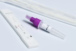 Equine Rapid Test Kits | Horse Disease Diagnostic Solutions 重点镜头展示了COVID-19快速核酸检测试剂盒,包括拭子、滴管和试纸,它们都位于白色表面上。